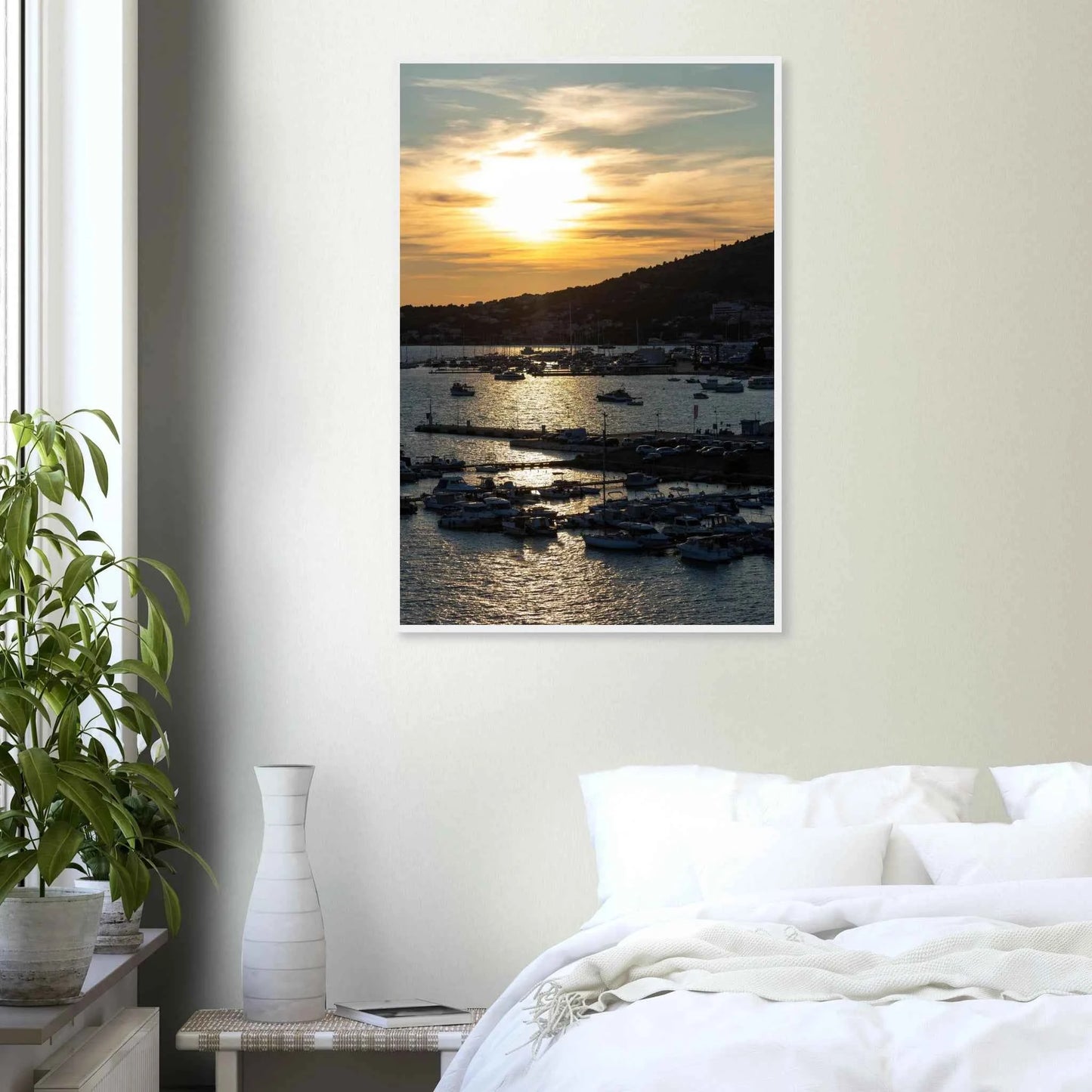 Wooden framed wall art of small boats anchored in a seaside port during Sunset at the harbor on the wall in the Bedroom