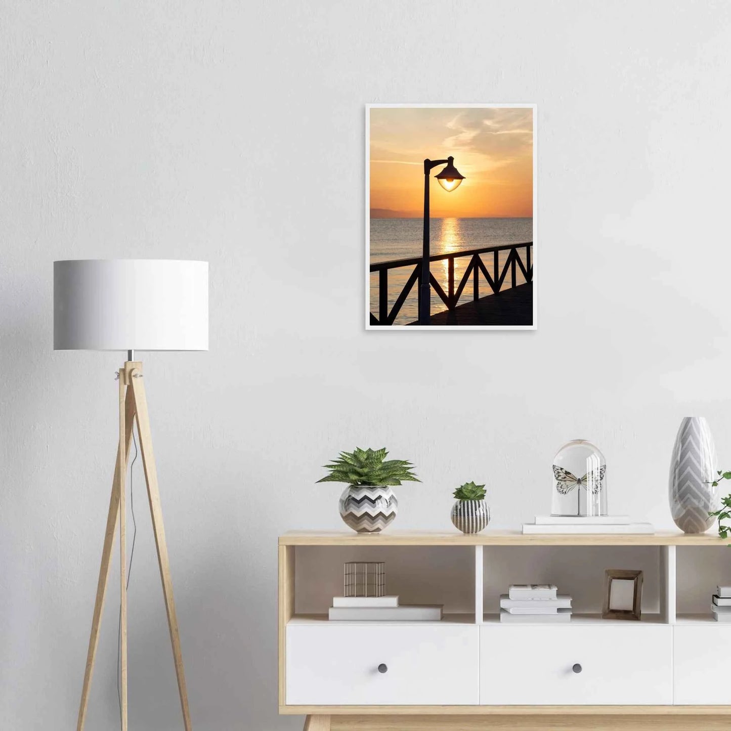 Wooden framed wall art of a sunset over the sea with a street lamp on the pier on the wall in the Livingroom