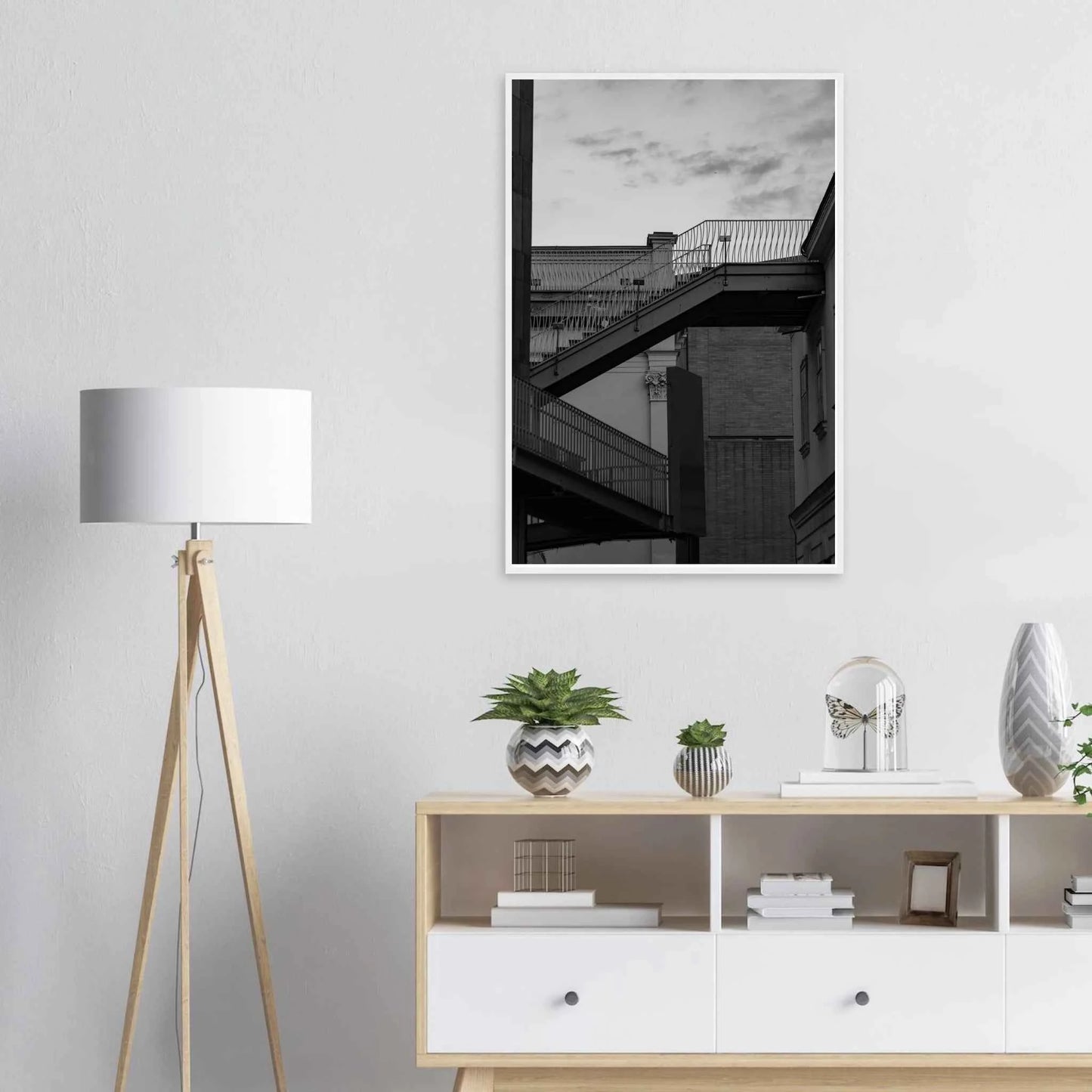 Black and white photo on a wooden frame wall art of an outdoor staircase connecting two buildings under a dramatic cloudy sky on the wall in the Livingroom
