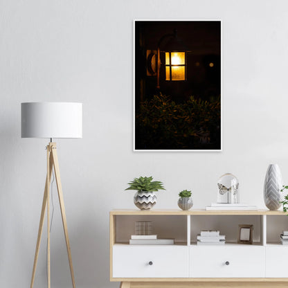 Glowing vintage lantern mounted on a wooden pole in front of a bush at night on wooden framed wall art on the wall in the Livingroom