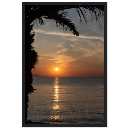 Wooden framed wall art Sunset over calm water with golden reflections, framed by tree branches in a peaceful natural landscape