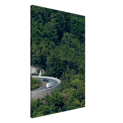 Aerial view of a winding road curve with cars surrounded by lush green forest landscape on Canvas print wall art