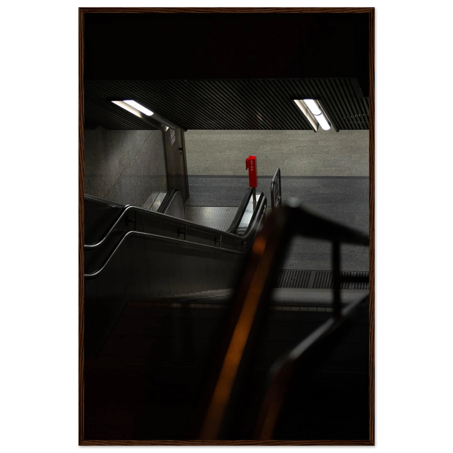 Nighttime view of a metro station entrance with illuminated signs and dark urban surroundings on wooden framed wall art