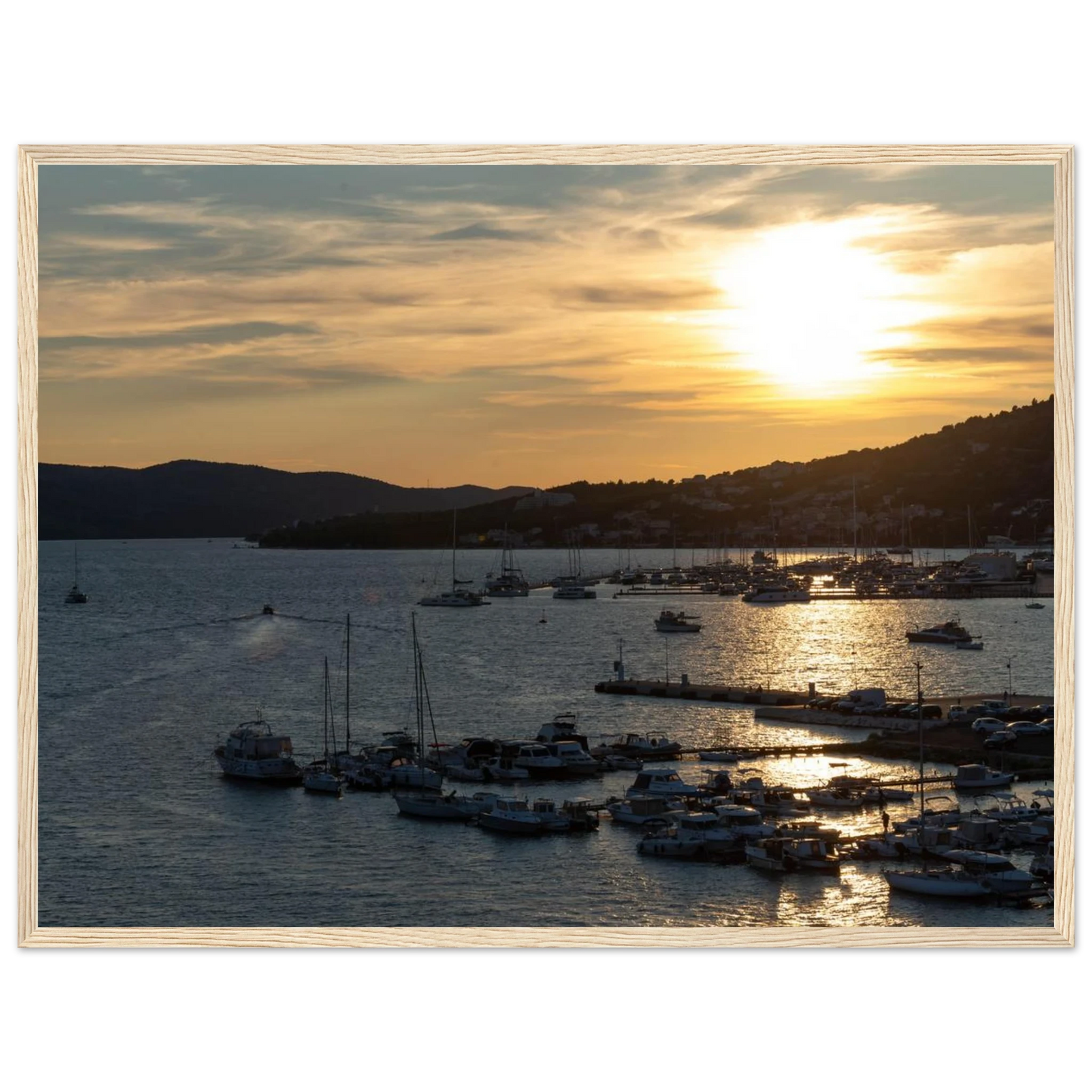 Wooden framed wall art of small boats anchored in a seaside port during Sunset at the harbor