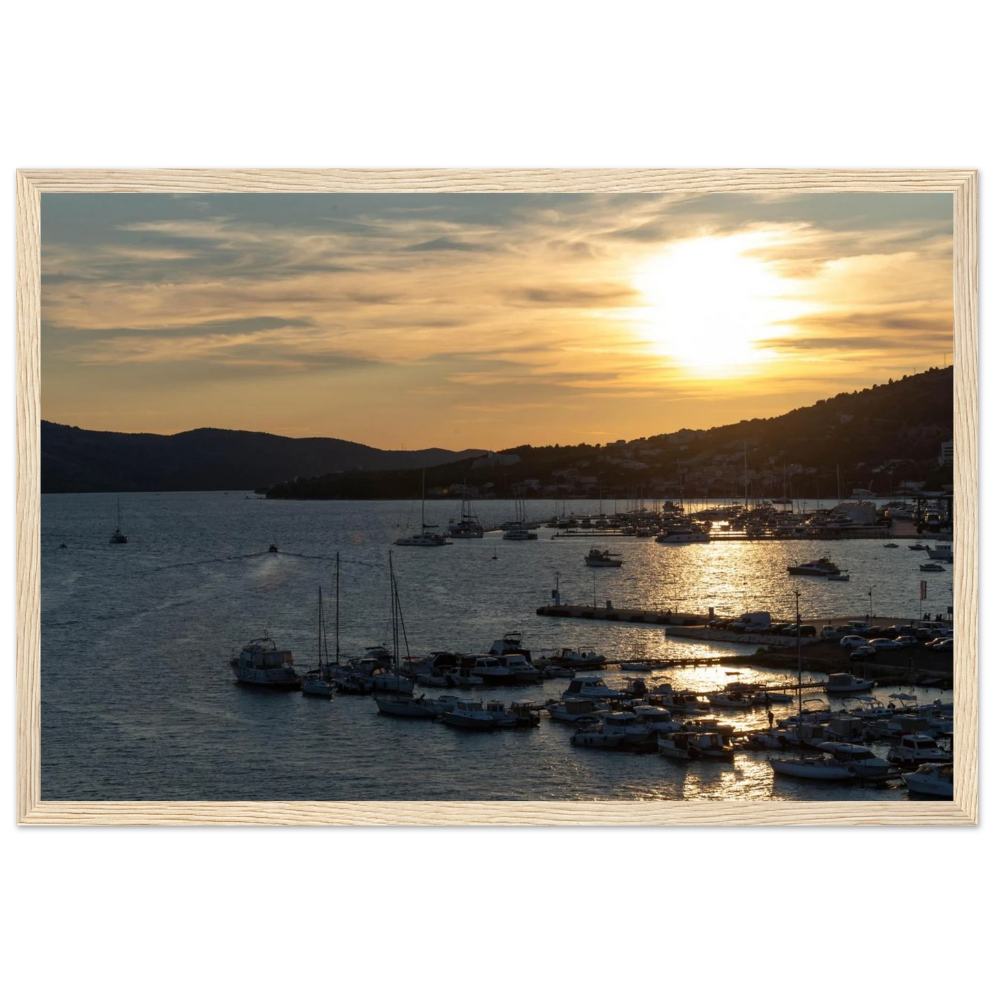 Wooden framed wall art of small boats anchored in a seaside port during Sunset at the harbor
