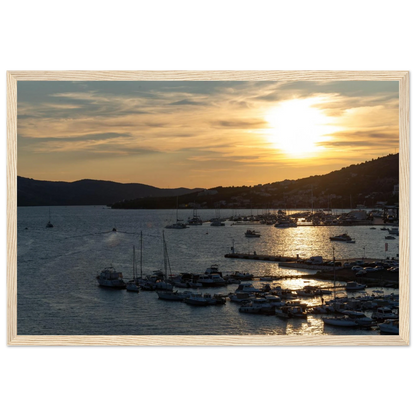 Wooden framed wall art of small boats anchored in a seaside port during Sunset at the harbor
