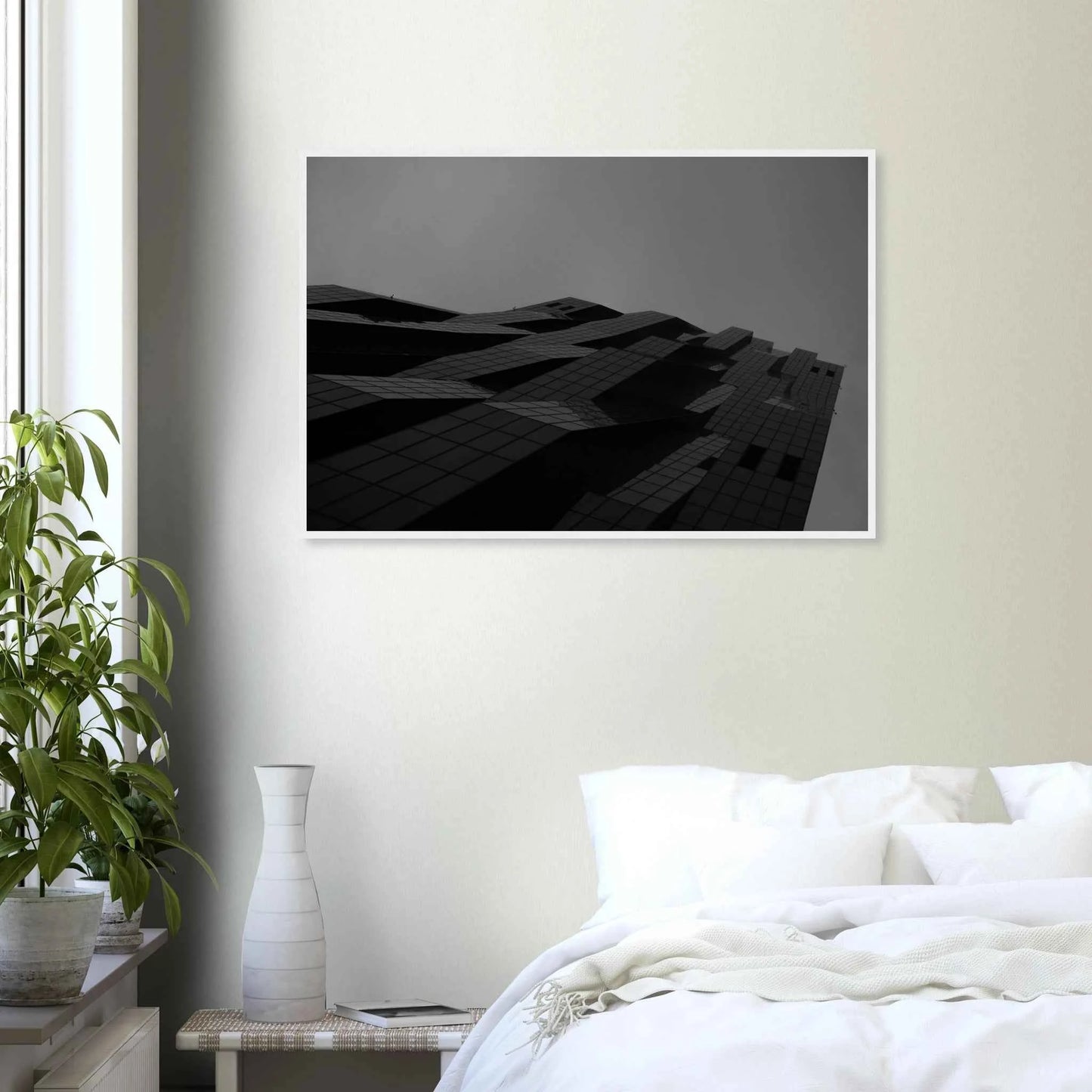 Black and white low angle view of a modern skyscraper with bold geometric lines and dark textured facade on wooden framed wall art on the wall in the Bedroom