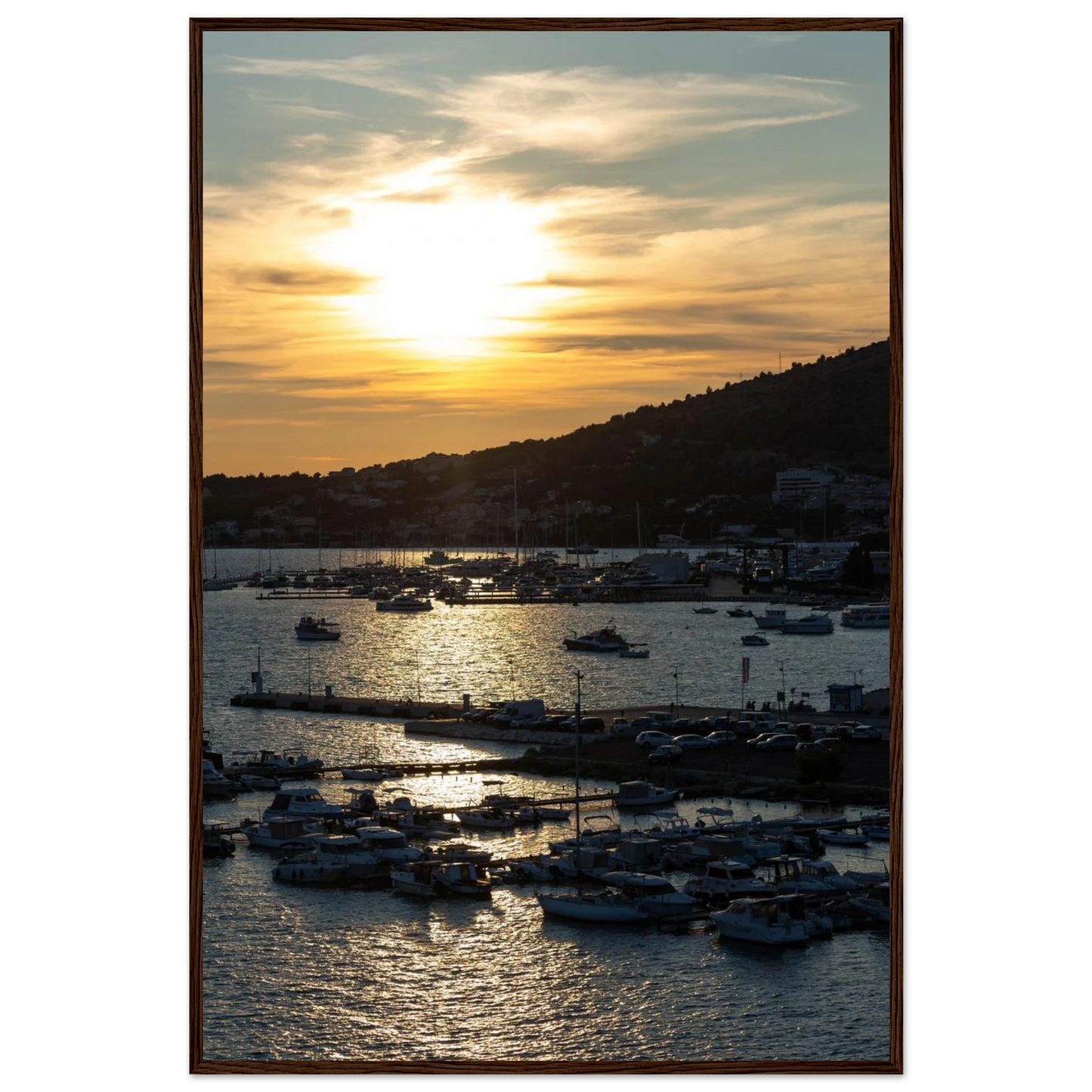 Wooden framed wall art of small boats anchored in a seaside port during Sunset at the harbor