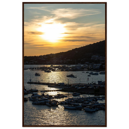 Wooden framed wall art of small boats anchored in a seaside port during Sunset at the harbor