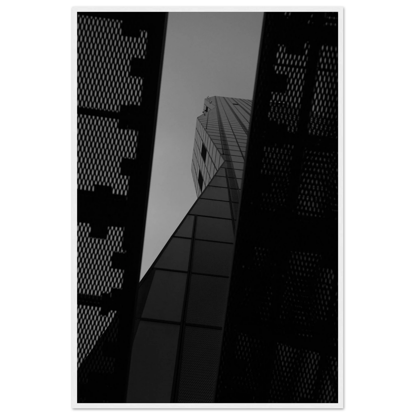 Black and white Low angle view looking up at a tall glass skyscraper framed between two metal structural elements on Wooden frame wall art