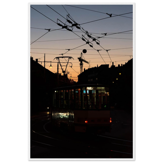 Wooden framed wall art featuring a tram the Nightline driving between houses under power lines during a golden sunset