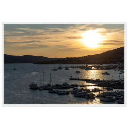 Wooden framed wall art of small boats anchored in a seaside port during Sunset at the harbor