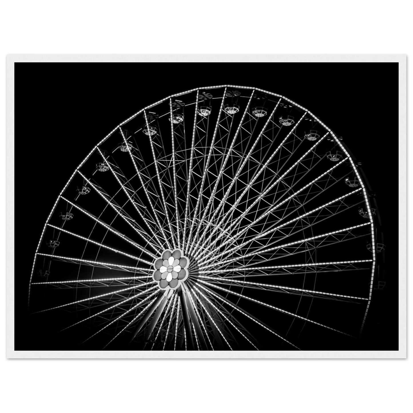 Black and white night photo of the Vienna Prater Giant Ferris Wheel (Wiener Riesenrad) with illuminated spokes forming a circular pattern against the dark sky on wooden framed wall art