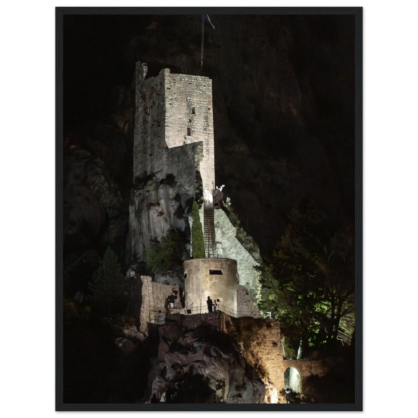 Wooden framed wall art of an ancient stone bastion decorated with green climbing plants against a dark background in Shadow Keep