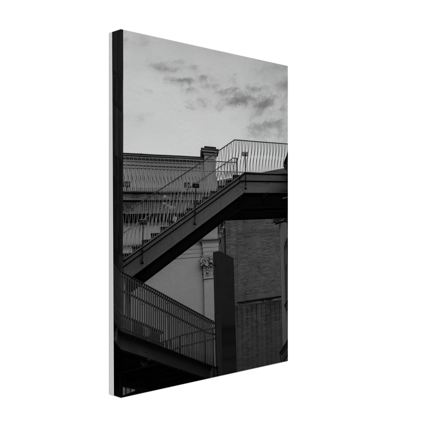 Black and white photo on a Canvas Print wall art of an outdoor staircase connecting two buildings under a dramatic cloudy sky