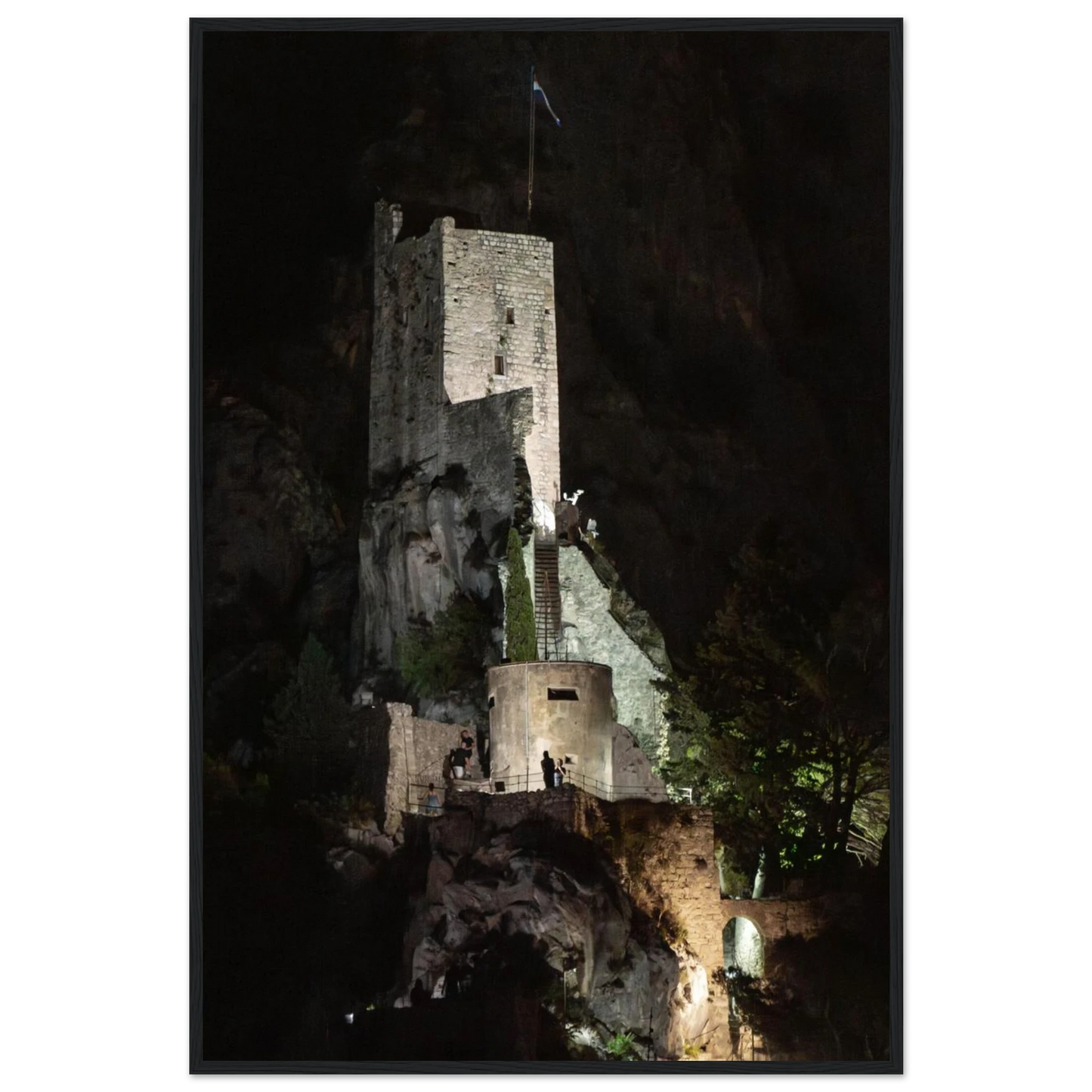 Wooden framed wall art of an ancient stone bastion decorated with green climbing plants against a dark background in Shadow Keep