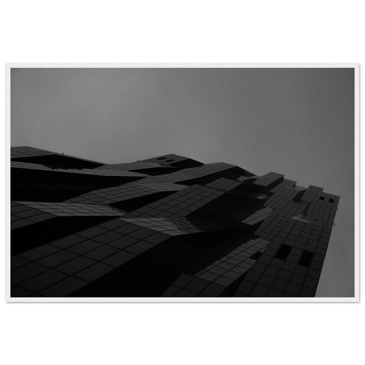 Black and white low angle view of a modern skyscraper with bold geometric lines and dark textured facade on wooden framed wall art
