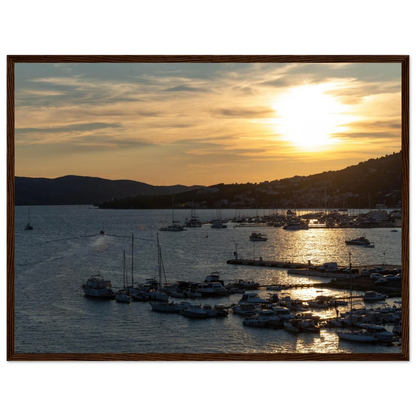 Wooden framed wall art of small boats anchored in a seaside port during Sunset at the harbor