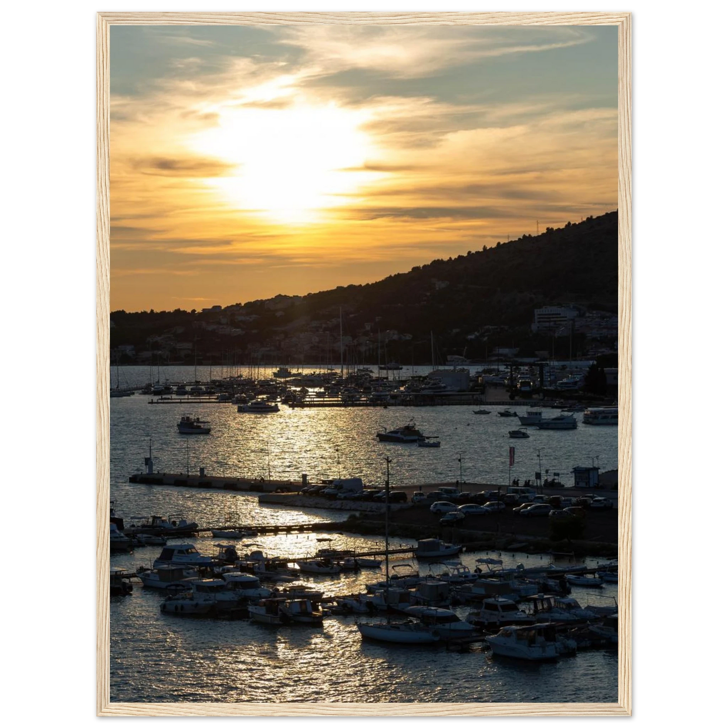 Wooden framed wall art of small boats anchored in a seaside port during Sunset at the harbor