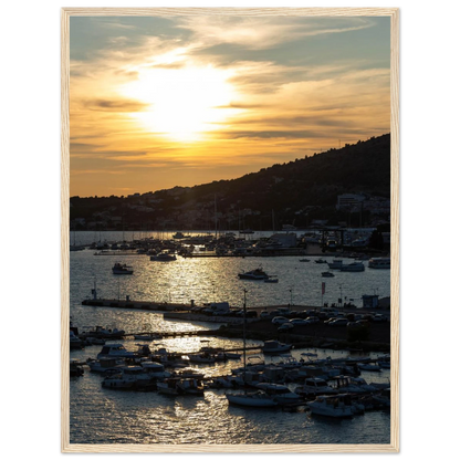 Wooden framed wall art of small boats anchored in a seaside port during Sunset at the harbor