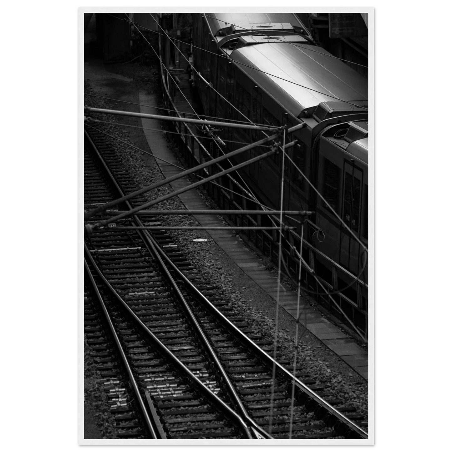 Black and white aerial view of metro train and railway tracks in an urban underground or elevated rail system on wooden framed wall art
