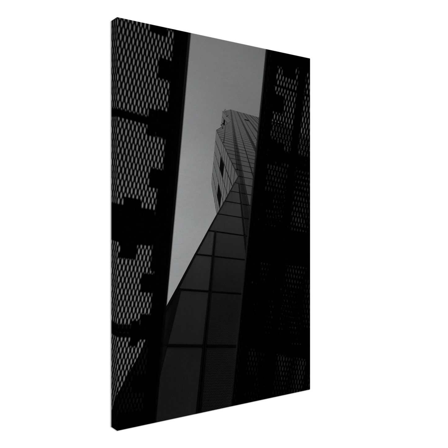 Black and white Low angle view looking up at a tall glass skyscraper framed between two metal structural elements on Canvas Print wall art