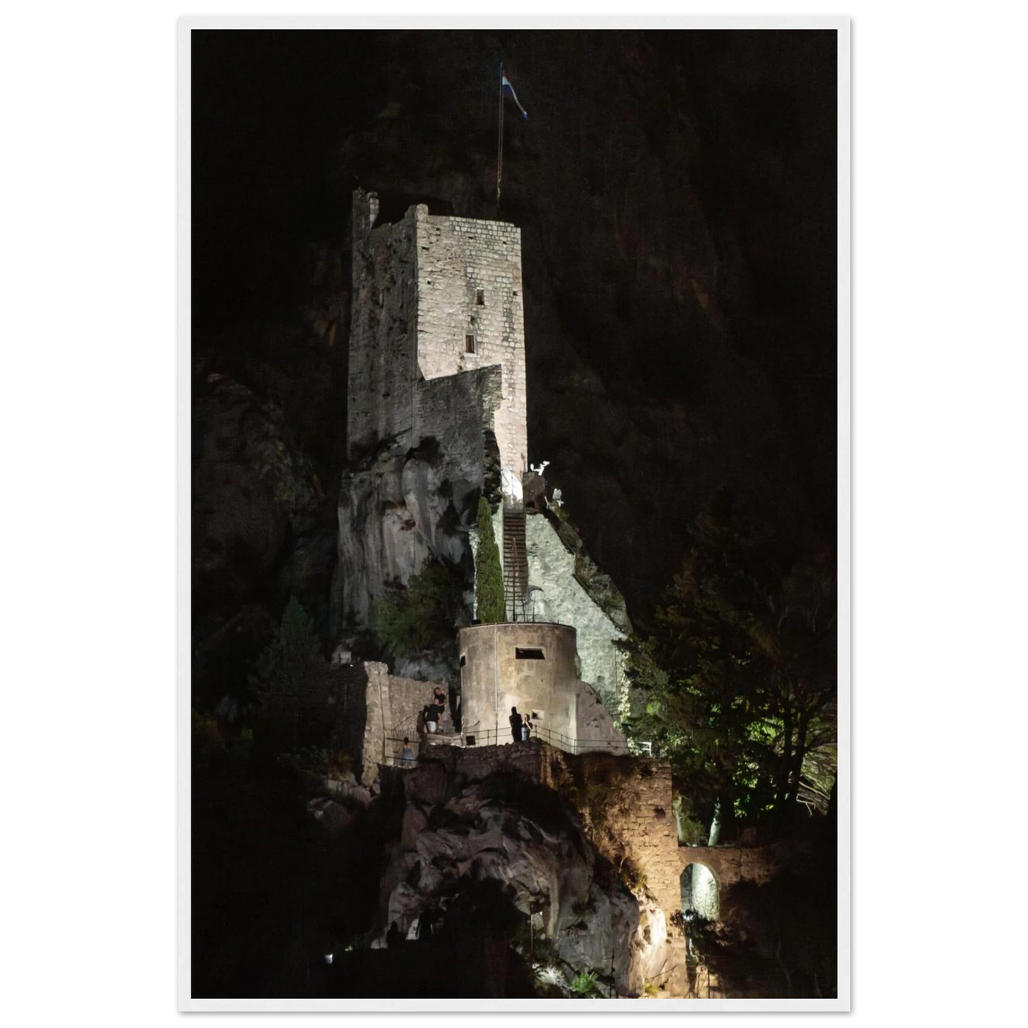 Wooden framed wall art of an ancient stone bastion decorated with green climbing plants against a dark background in Shadow Keep