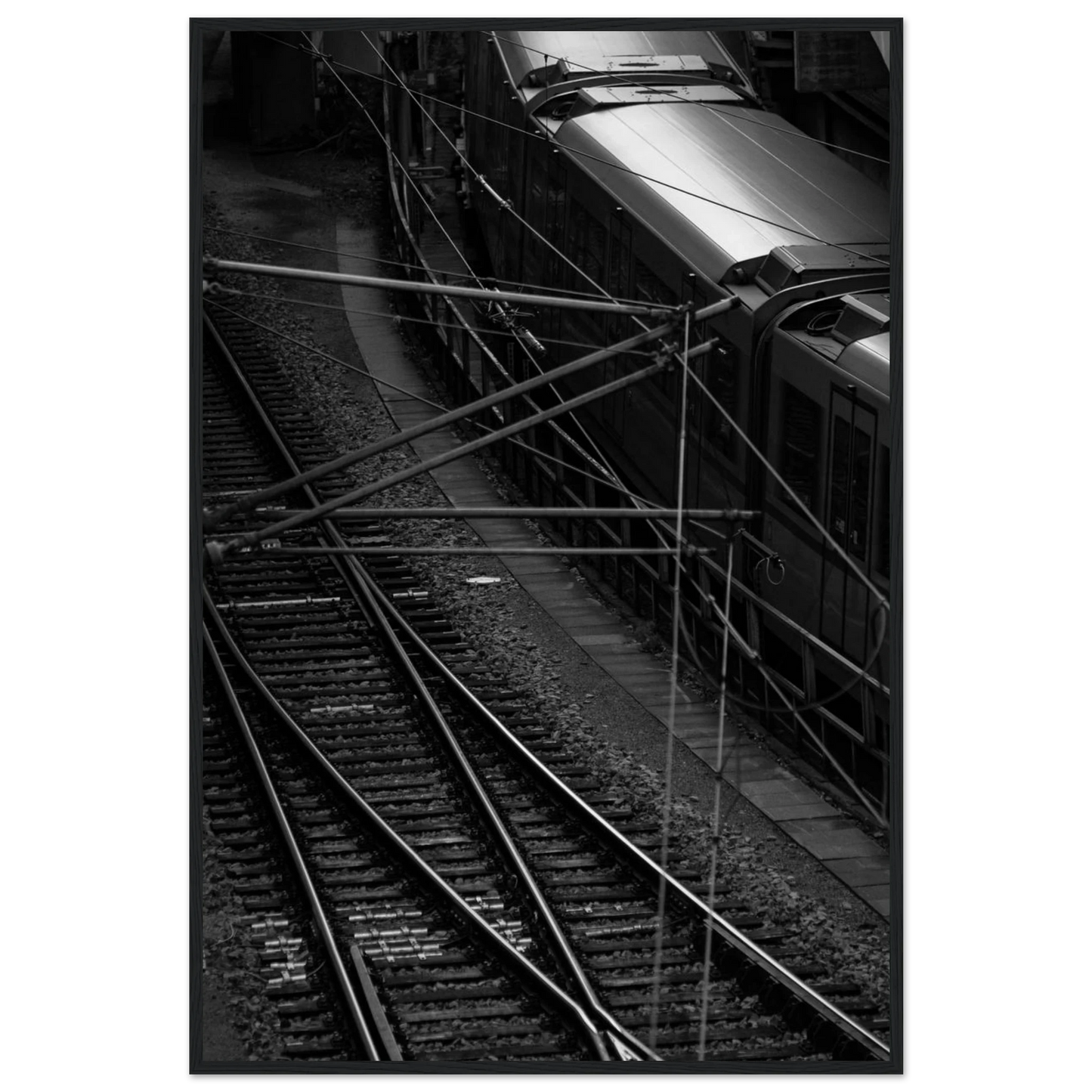 Black and white aerial view of metro train and railway tracks in an urban underground or elevated rail system on wooden framed wall art