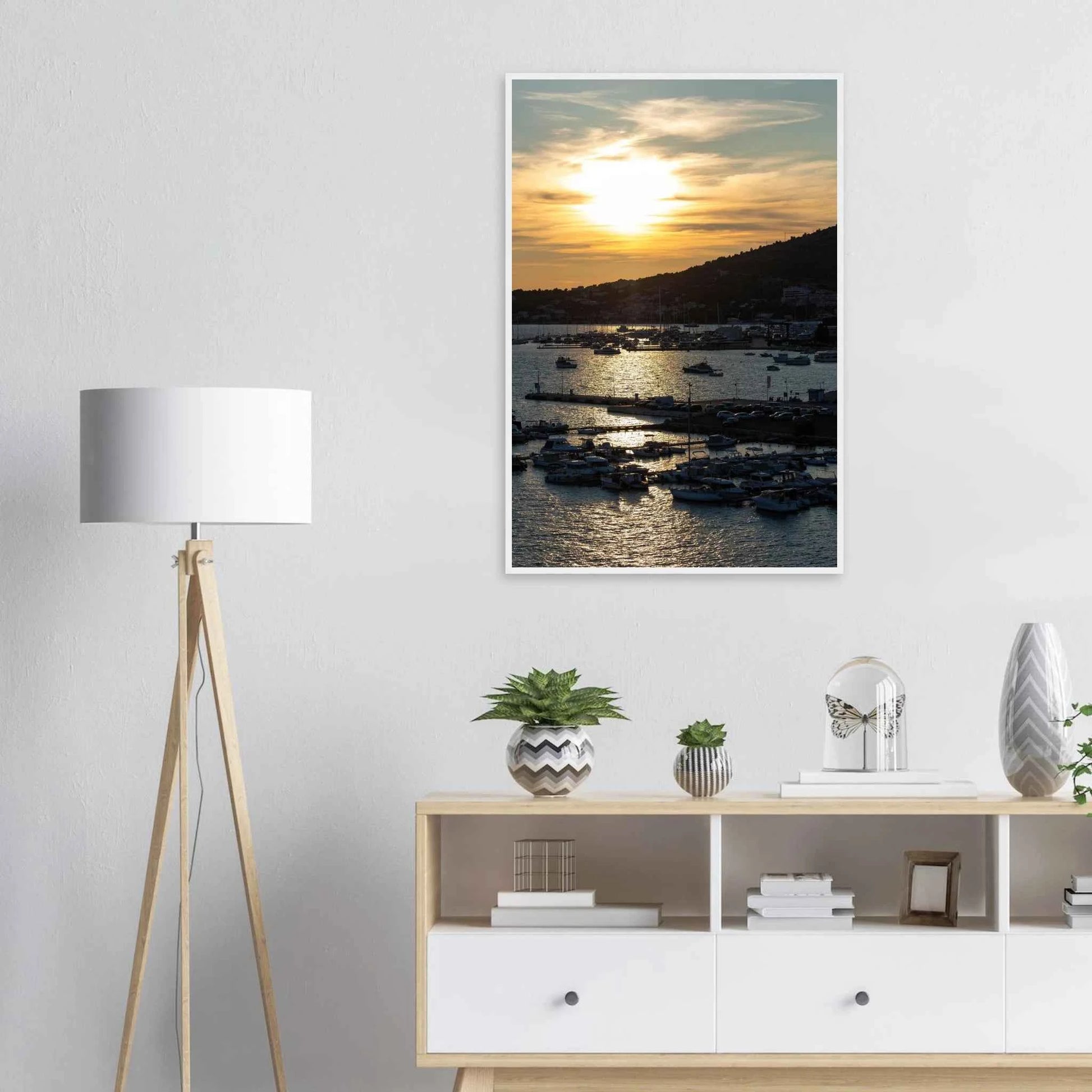 Wooden framed wall art of small boats anchored in a seaside port during Sunset at the harbor on the wall in the Bedroom