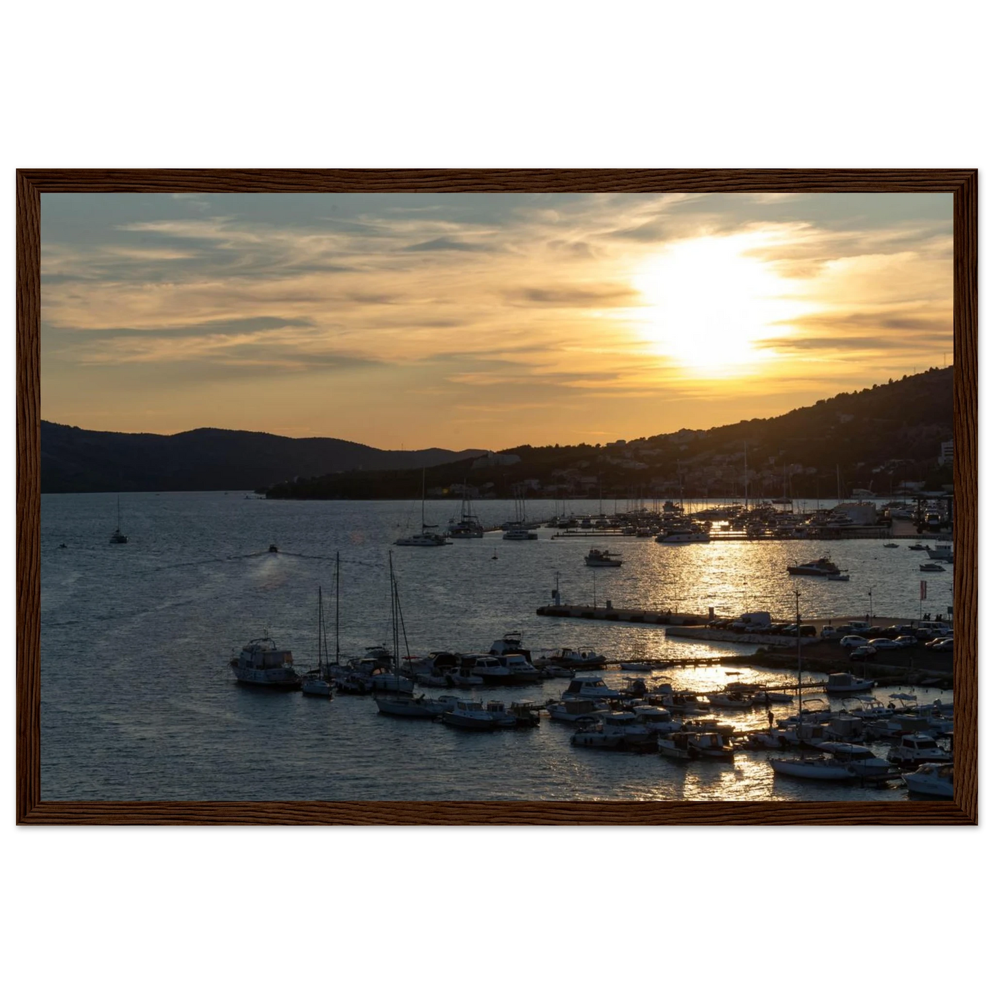 Wooden framed wall art of small boats anchored in a seaside port during Sunset at the harbor