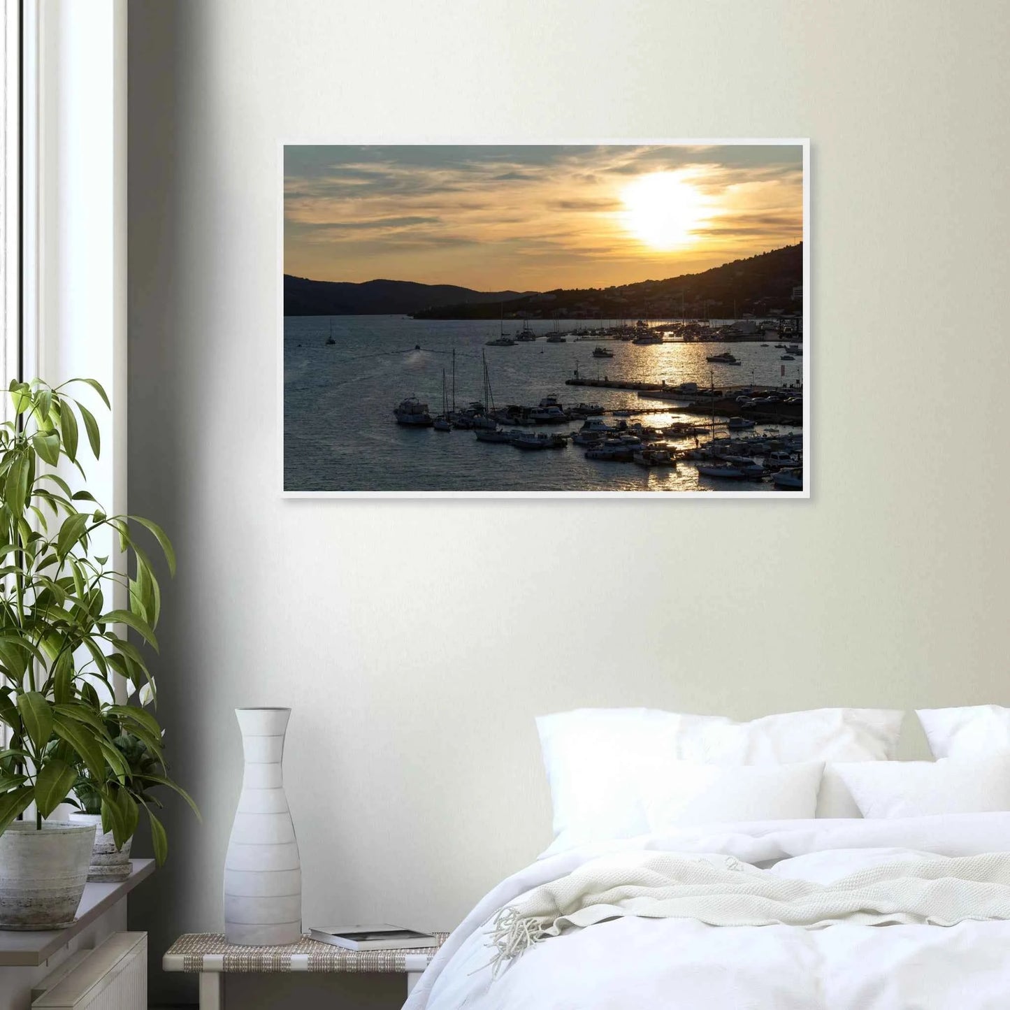 Wooden framed wall art of small boats anchored in a seaside port during Sunset at the harbor on the wall in the Bedroom