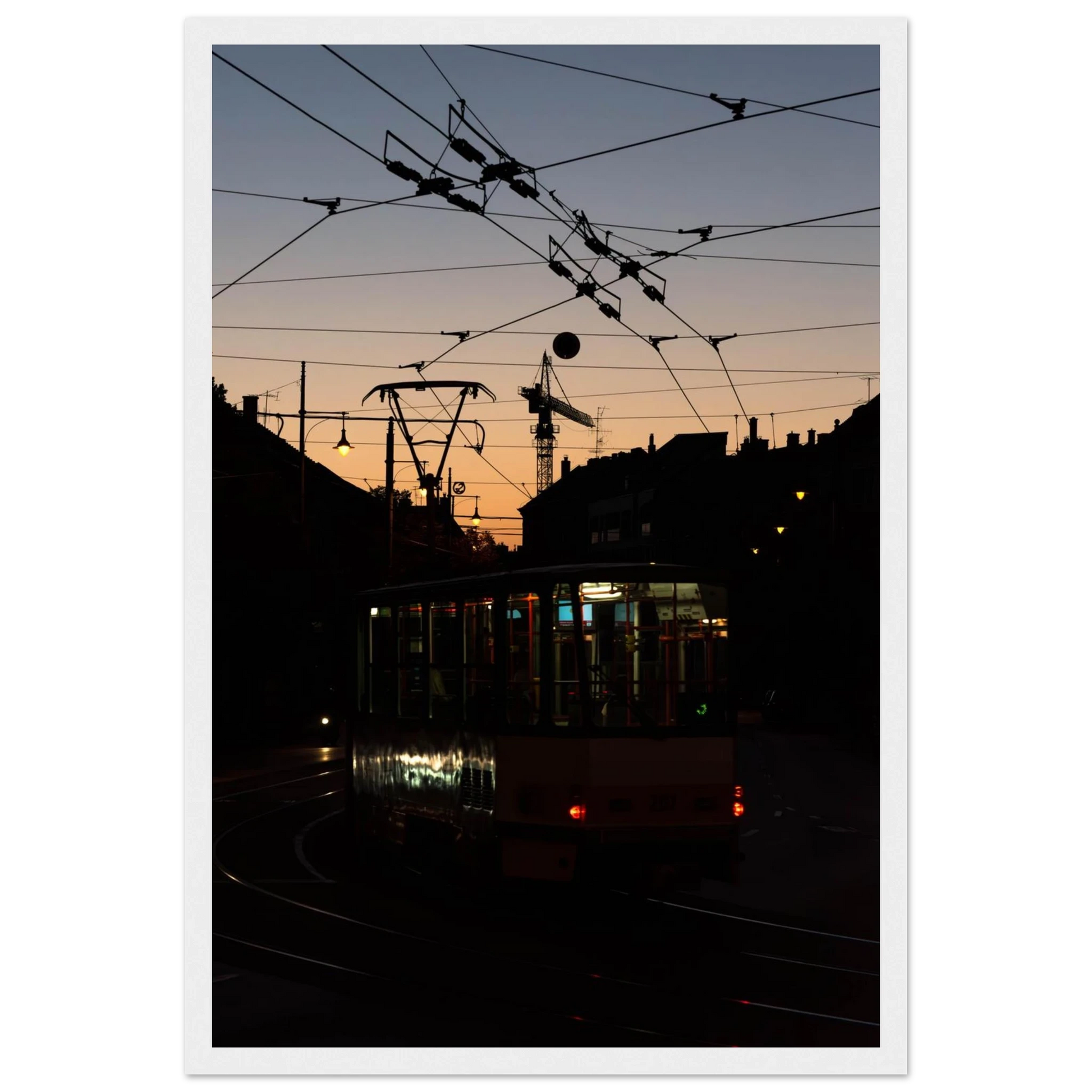 Wooden framed wall art featuring a tram the Nightline driving between houses under power lines during a golden sunset