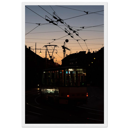Wooden framed wall art featuring a tram the Nightline driving between houses under power lines during a golden sunset