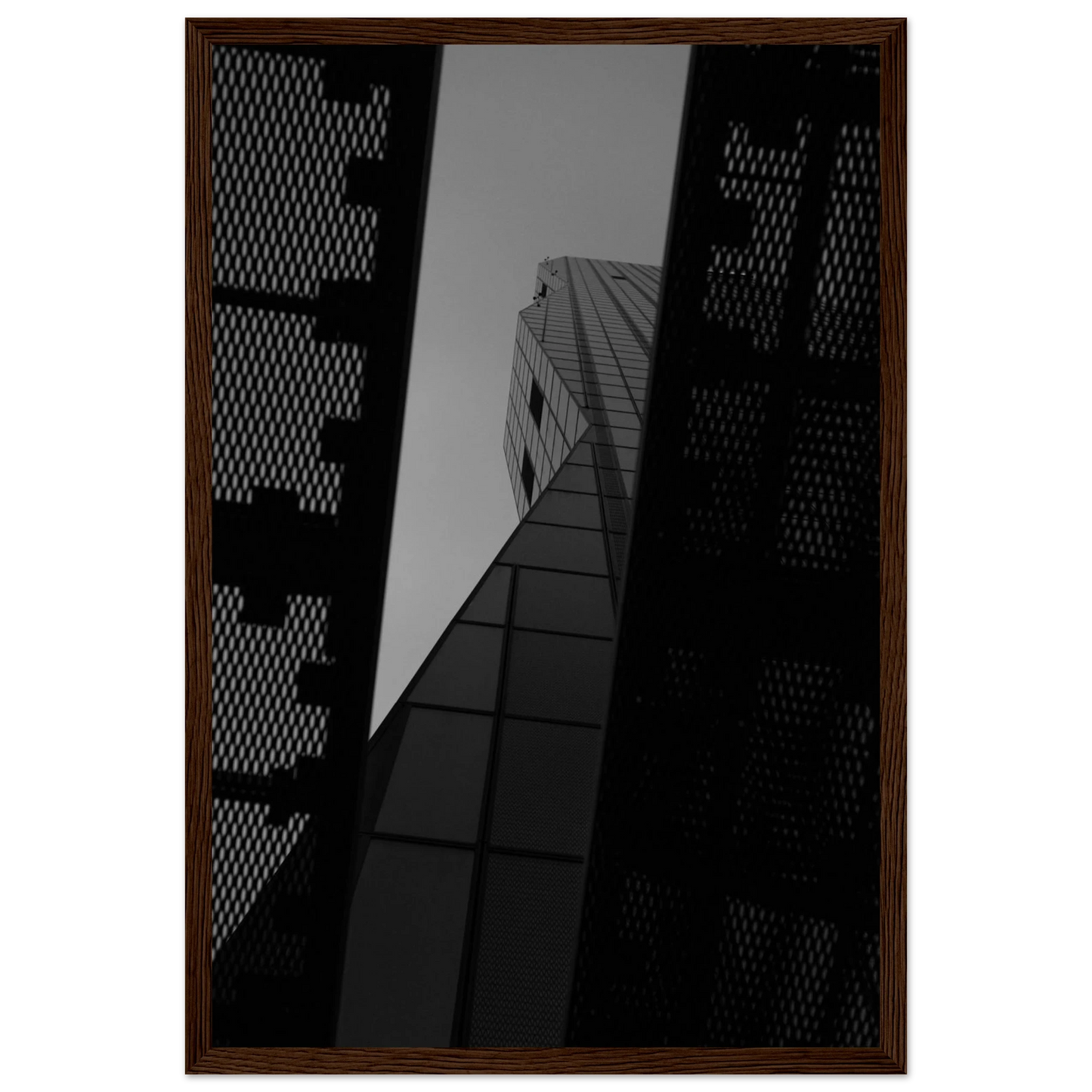 Black and white Low angle view looking up at a tall glass skyscraper framed between two metal structural elements on Wooden frame wall art