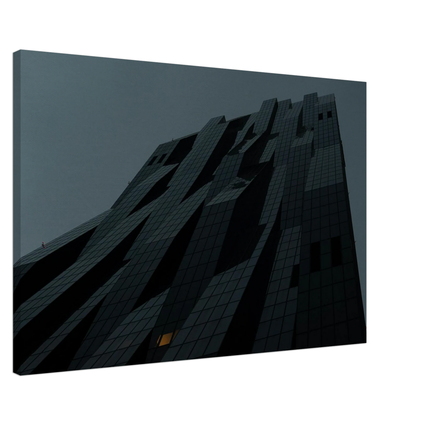Bluish low angle view of a modern skyscraper with bold geometric lines and dark textured facade on Canvas Print wall art