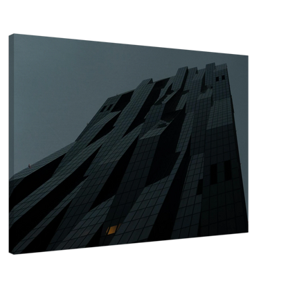 Bluish low angle view of a modern skyscraper with bold geometric lines and dark textured facade on Canvas Print wall art