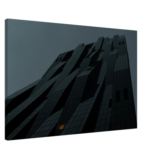 Bluish low angle view of a modern skyscraper with bold geometric lines and dark textured facade on Canvas Print wall art