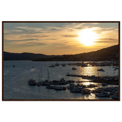 Wooden framed wall art of small boats anchored in a seaside port during Sunset at the harbor