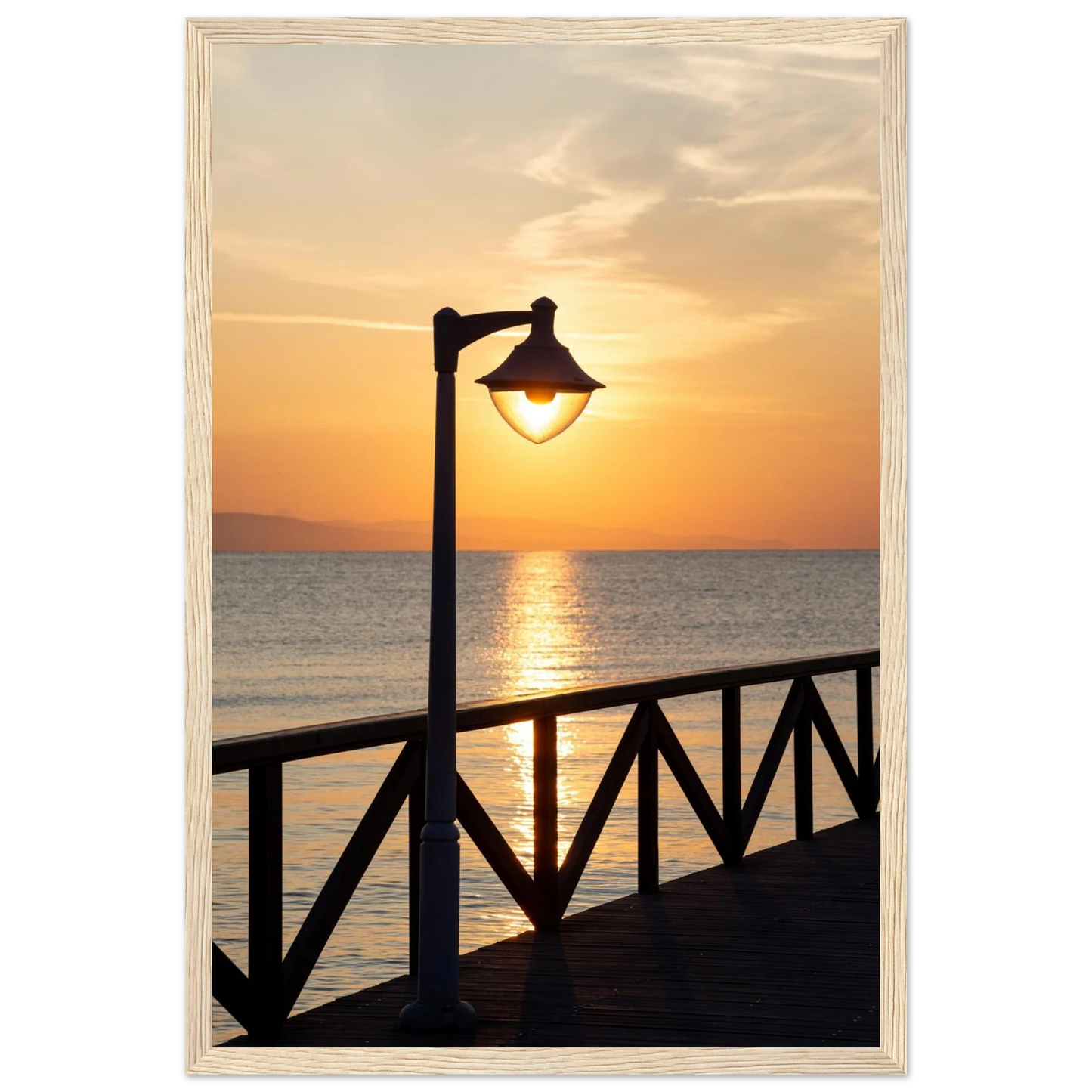 Wooden framed wall art of a sunset over the sea with a street lamp on the pier