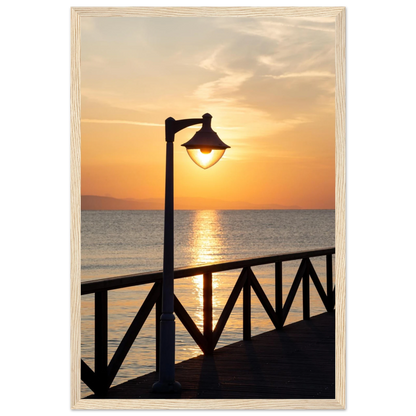 Wooden framed wall art of a sunset over the sea with a street lamp on the pier