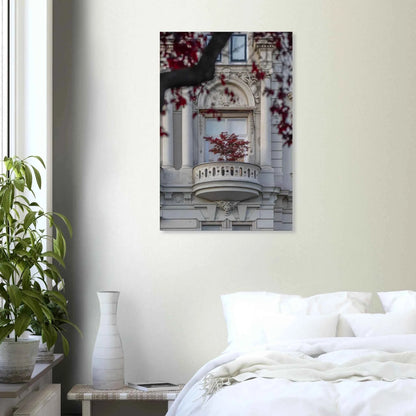 Red leaved tree in autumn colors in front of a historic stone building facade on Canvas Print wall art on the wall in the Bedroom
