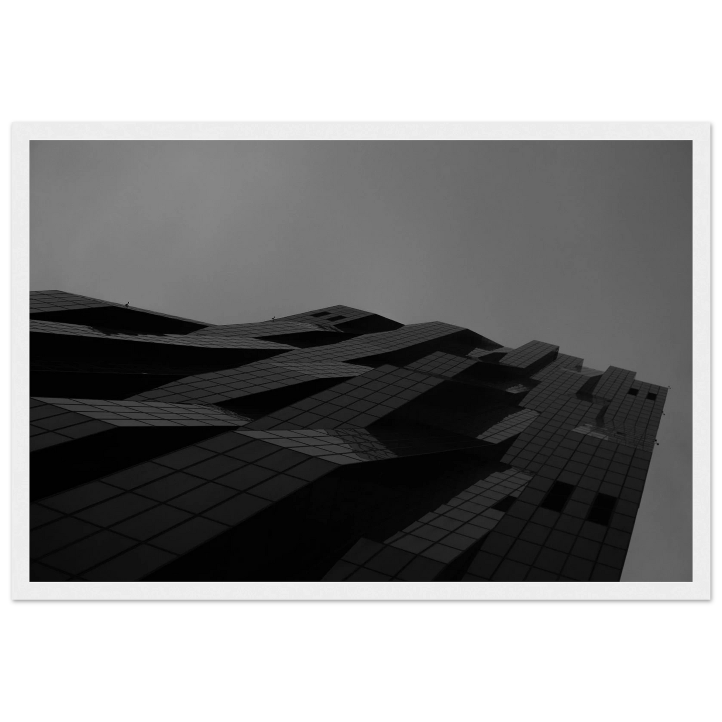 Black and white low angle view of a modern skyscraper with bold geometric lines and dark textured facade on wooden framed wall art