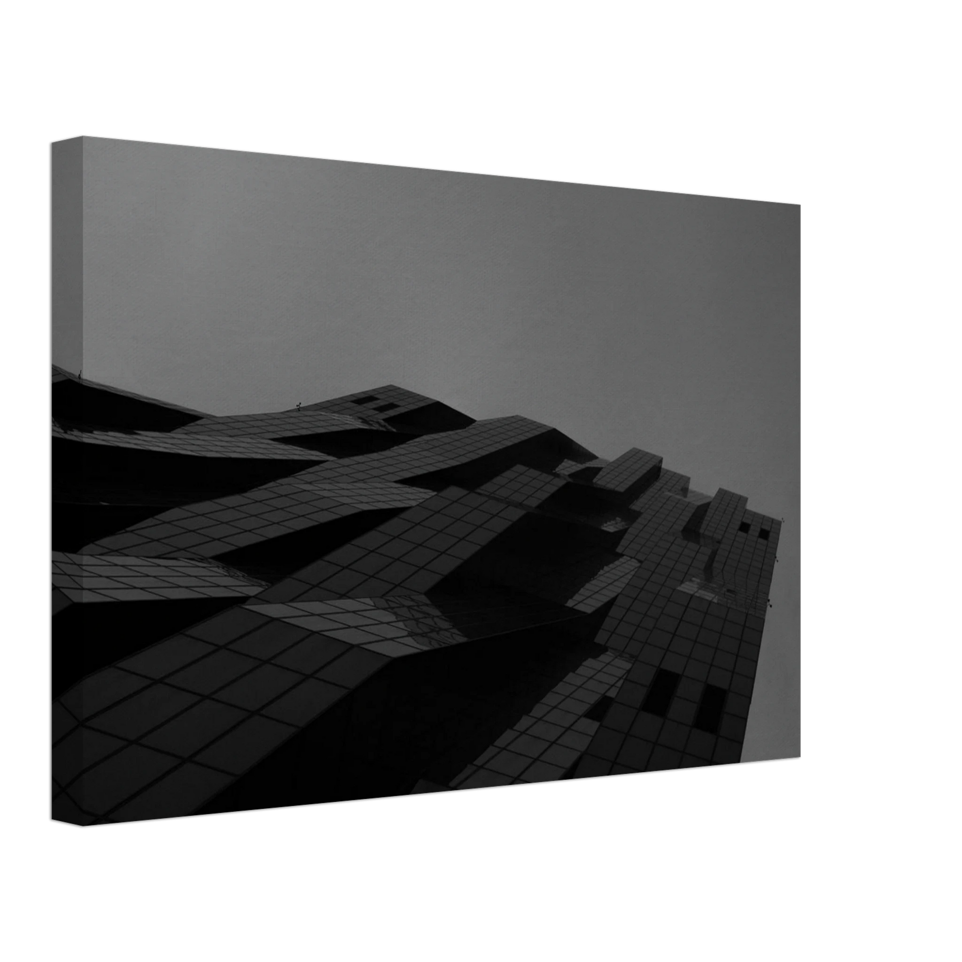 Black and white low angle view of a modern skyscraper with bold geometric lines and dark textured facade on Canvas Print wall art