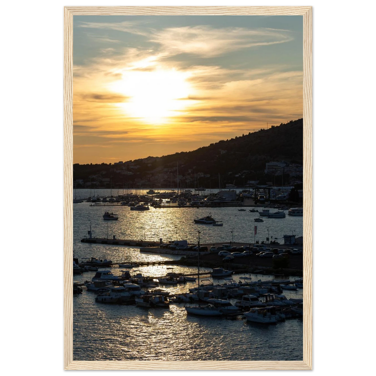 Wooden framed wall art of small boats anchored in a seaside port during Sunset at the harbor