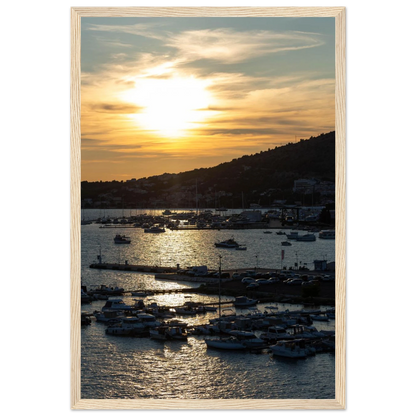 Wooden framed wall art of small boats anchored in a seaside port during Sunset at the harbor