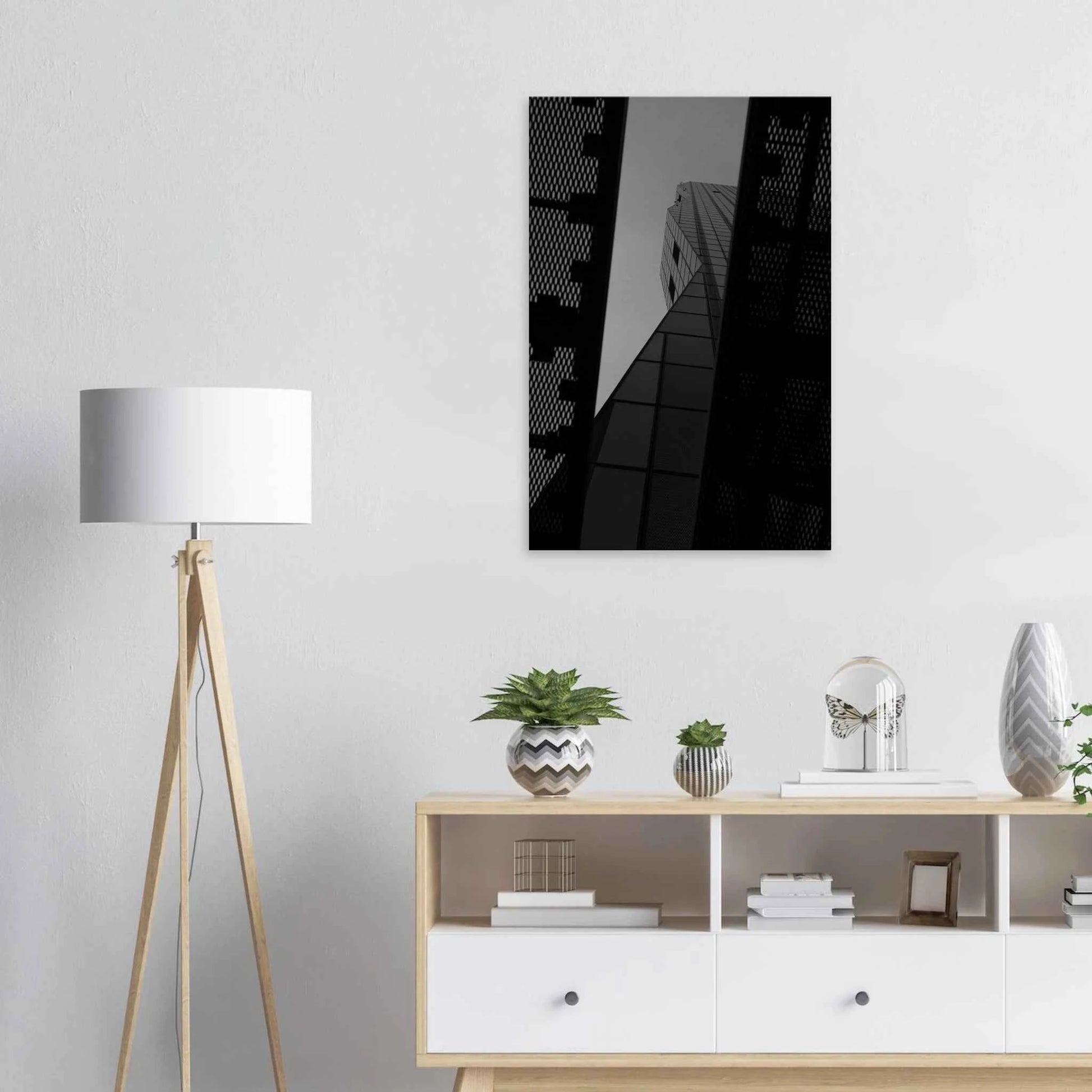 Black and white Low angle view looking up at a tall glass skyscraper framed between two metal structural elements on Canvas Print wall art on the wall in the Livingroom