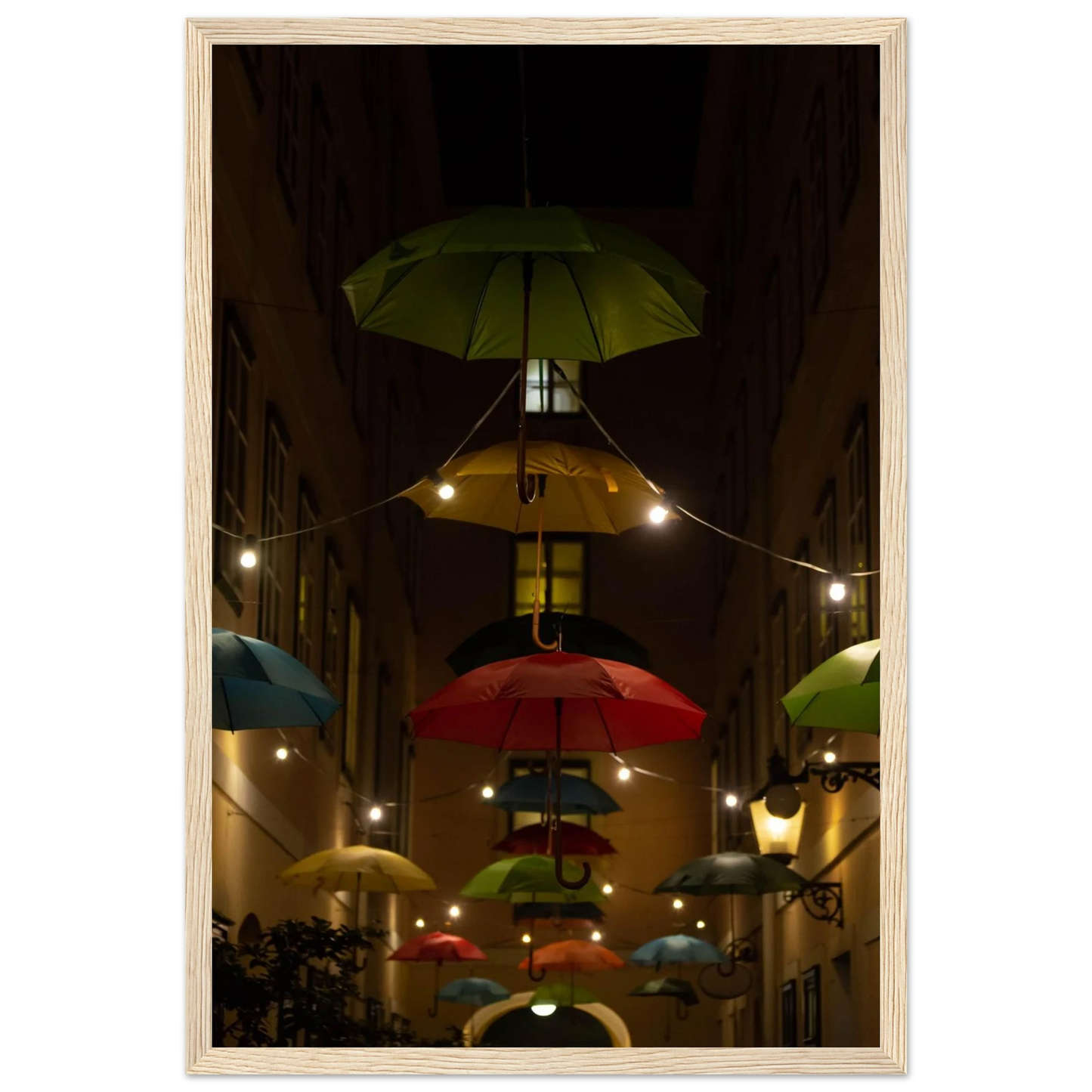 Nighttime street scene with colorful illuminated umbrellas hanging as decoration above a vibrant outdoor area on a wooden frame wall art