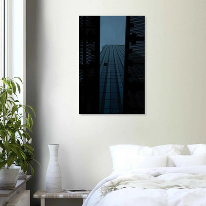 Low angle view looking up at a tall glass skyscraper framed between two metal structural elements on Canvas Print wall art on the wall in the Bedroom