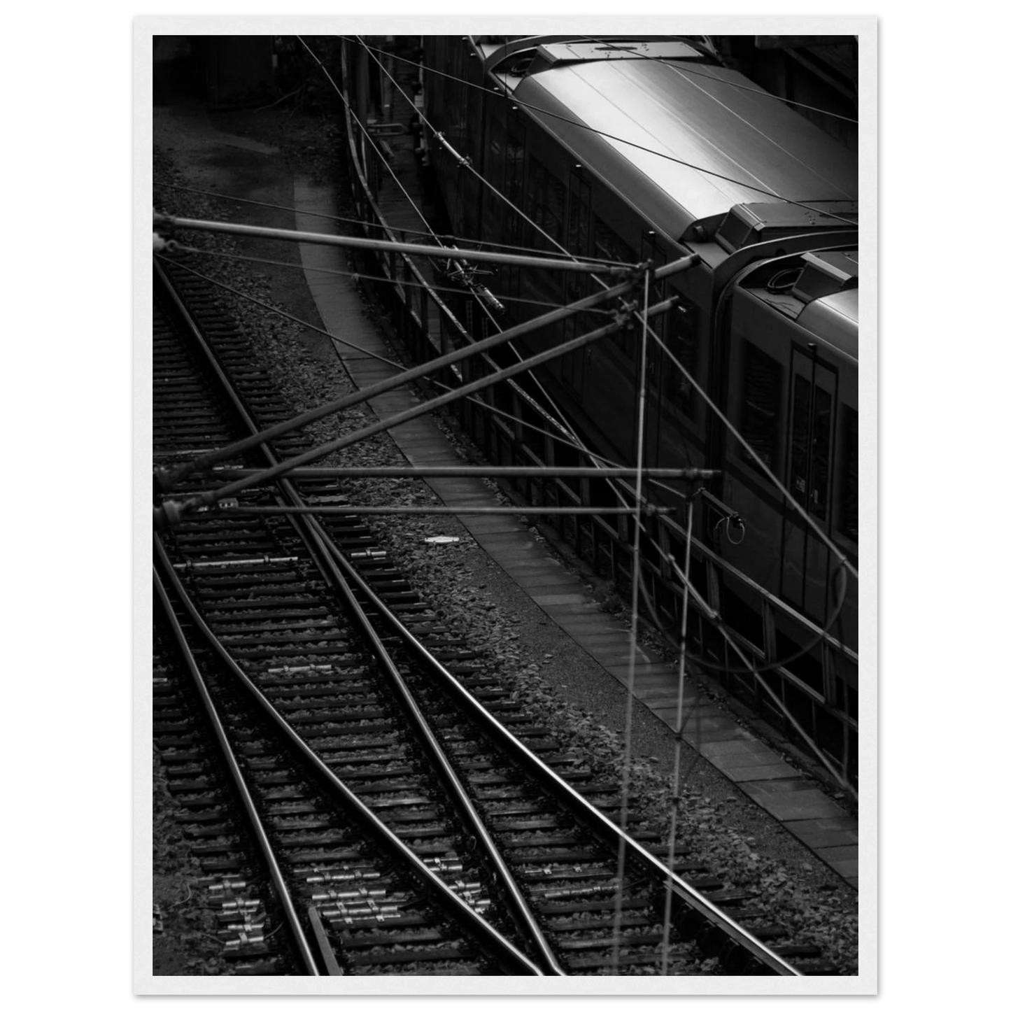 Black and white aerial view of metro train and railway tracks in an urban underground or elevated rail system on wooden framed wall art