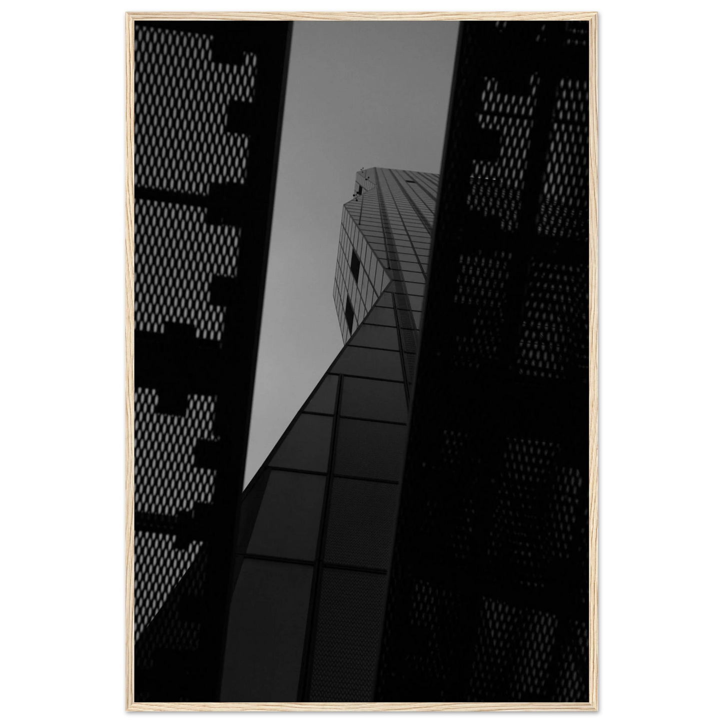 Black and white Low angle view looking up at a tall glass skyscraper framed between two metal structural elements on Wooden frame wall art